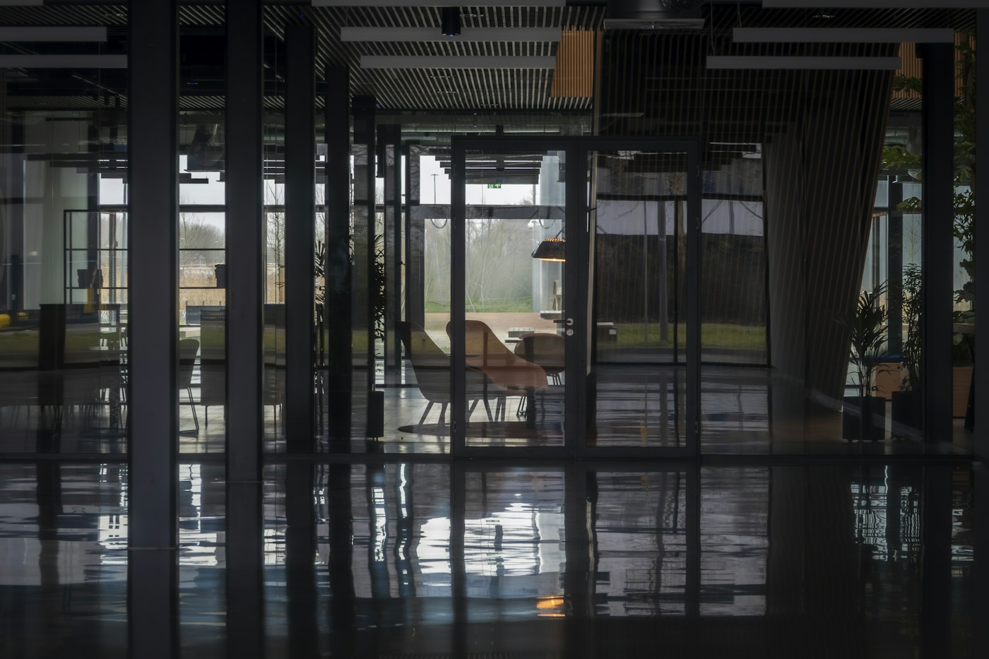 Commercial interior with glass partitions and overhead lighting